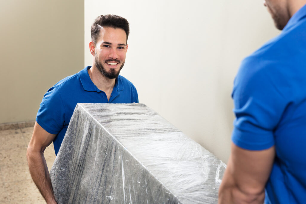 Two Movers Carrying Furniture On Staircase